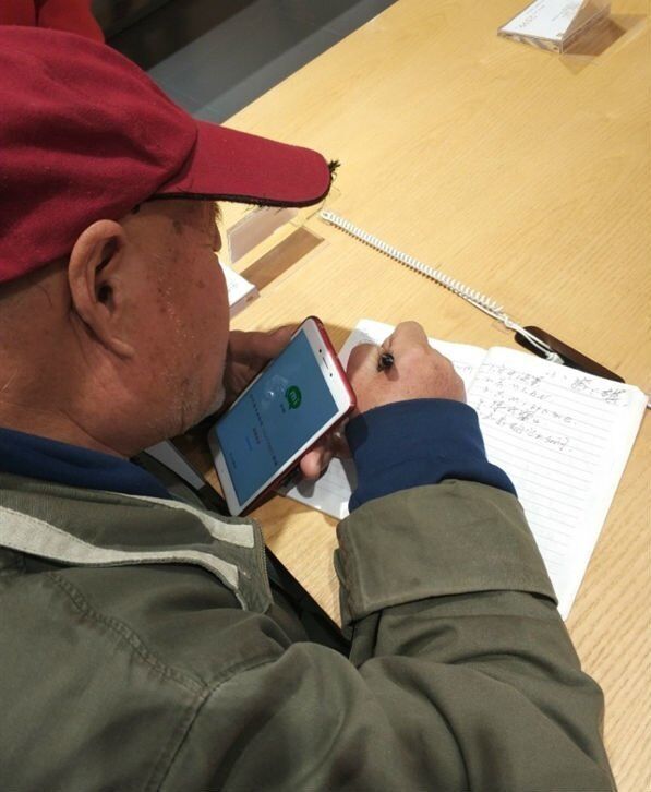 Пожилой покупатель осваивает азы работы со смартфоном